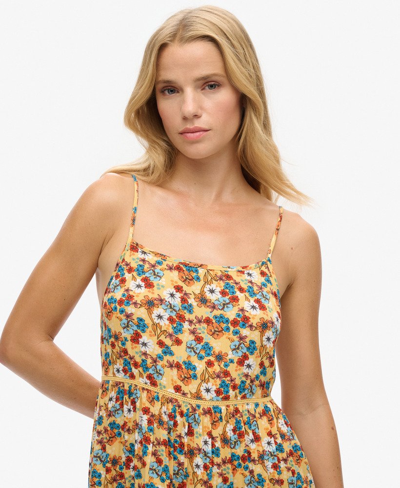 mini vestido de alcinha para praia em estampa floral amarela estilo anos 70.
