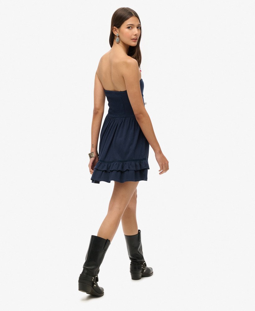 vestido curto bandeau de renda estilo anos 50 em um tom azul marinho intenso.