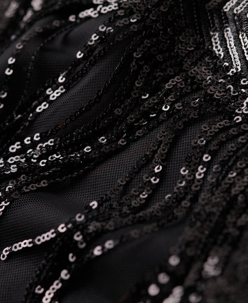 vestido curto evasê com franjas e lantejoulas pretas.