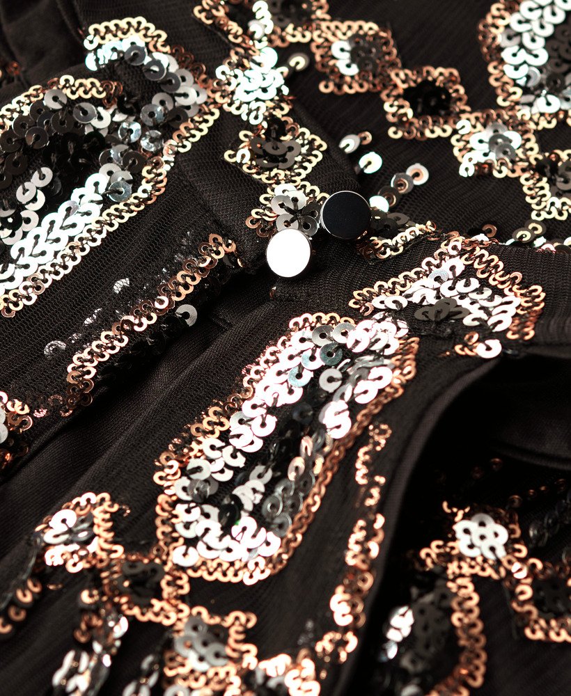 vestido evasê com decote halter e franjas decorativas em lantejoulas.