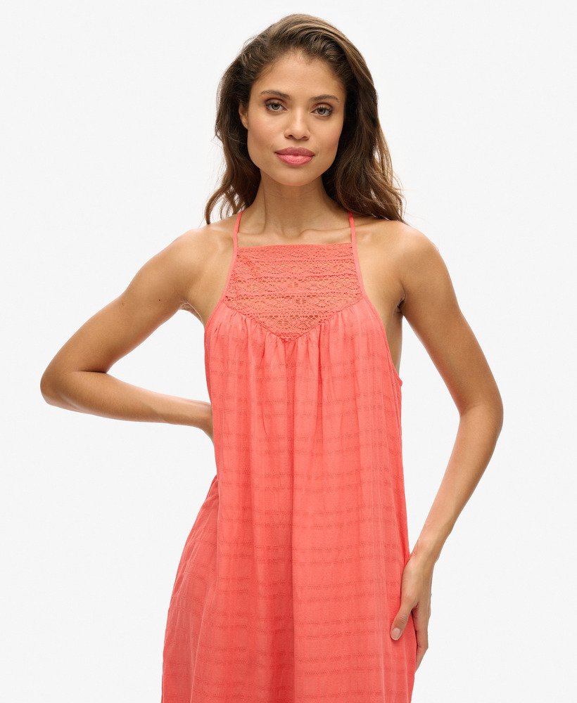 vestido longo de praia com renda e decote halter na cor coral rosado.