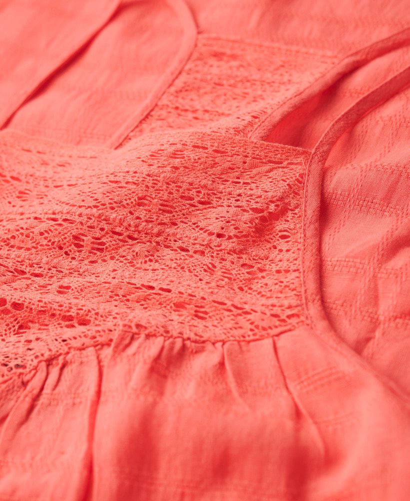 vestido longo de praia com renda e decote halter na cor coral rosado.