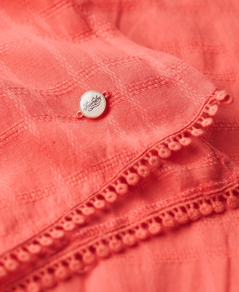 vestido longo de praia com renda e decote halter na cor coral rosado.
