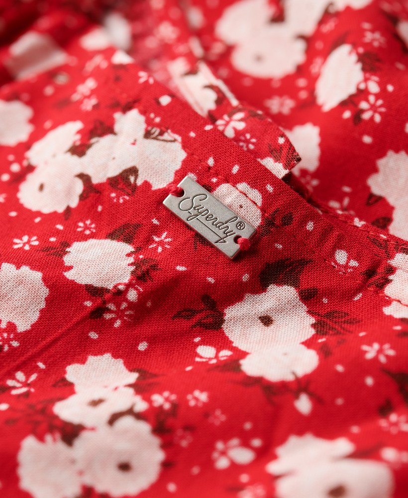 vestido midi de alcinha com estampa floral miúda em tons de rosa e fechamento frontal por botões.