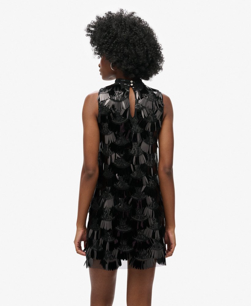 vestido evasê com franjas e lantejoulas pretas.