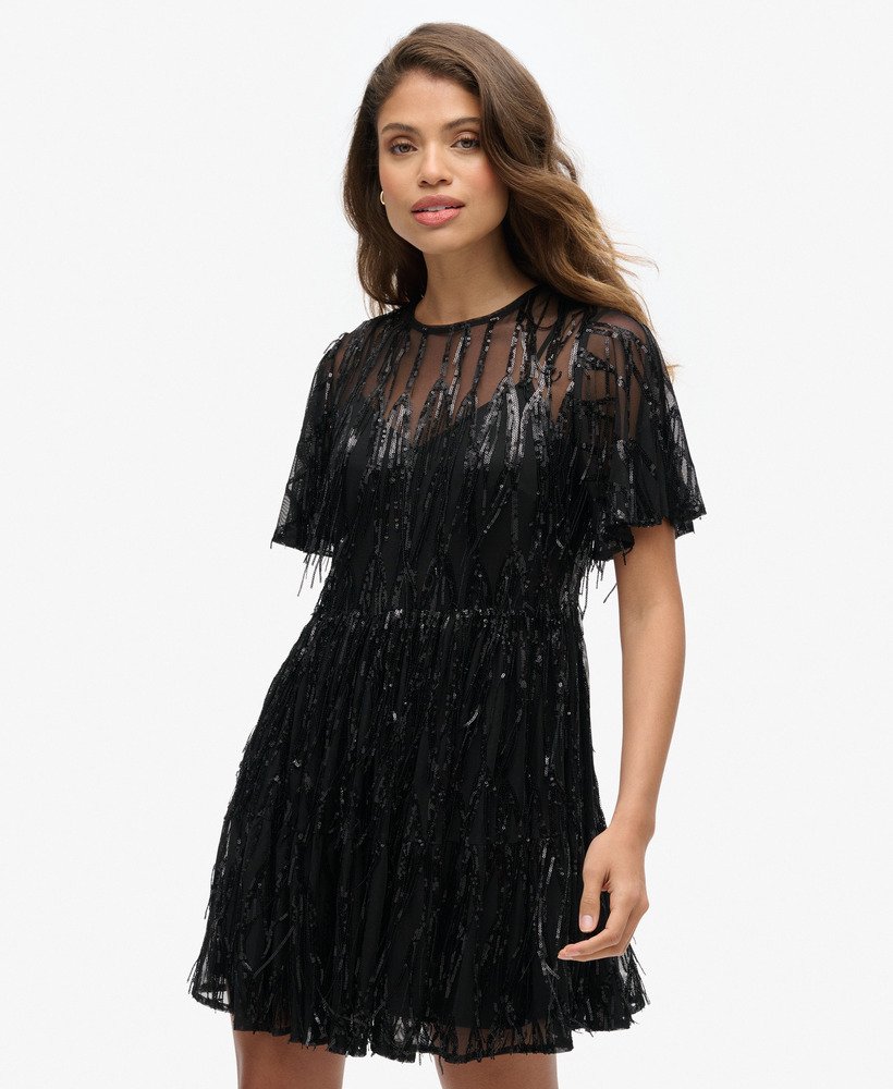 vestido curto volumoso em camadas de tule com franjas e lantejoulas pretas.