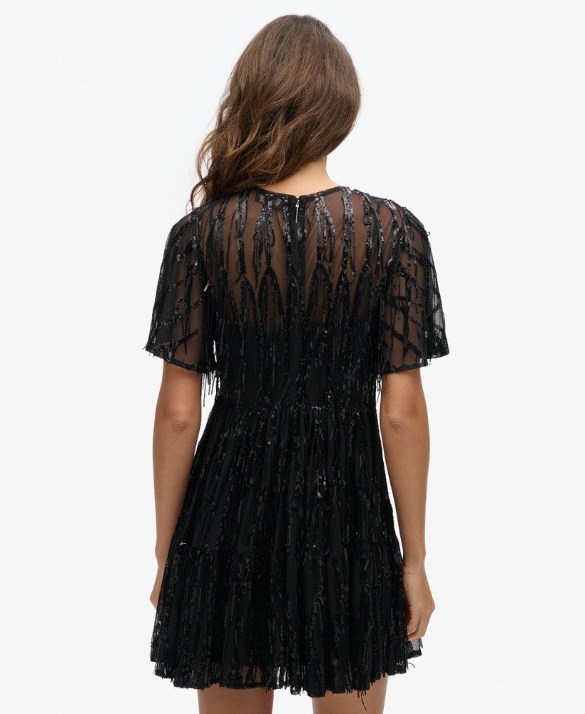vestido curto volumoso em camadas de tule com franjas e lantejoulas pretas.