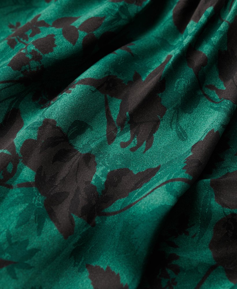 vestido longo jacquard com decote drapeado e estampa floral em tons de azul-petróleo.