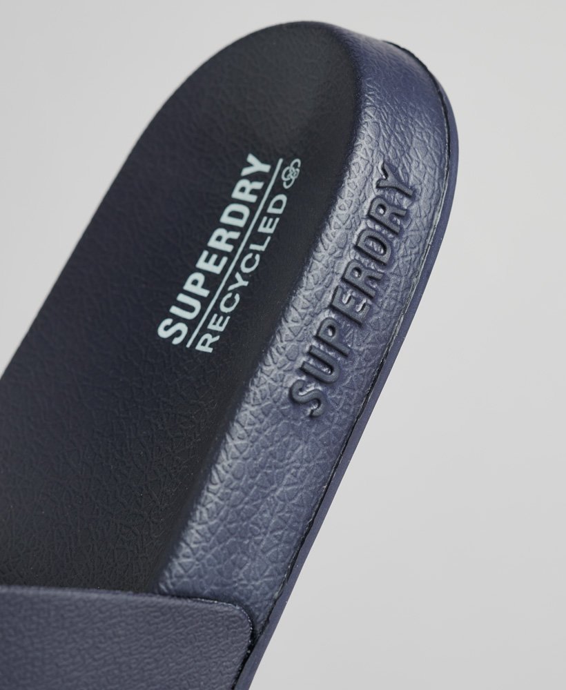 sliders de piscina com o logotipo code em azul marinho intenso.