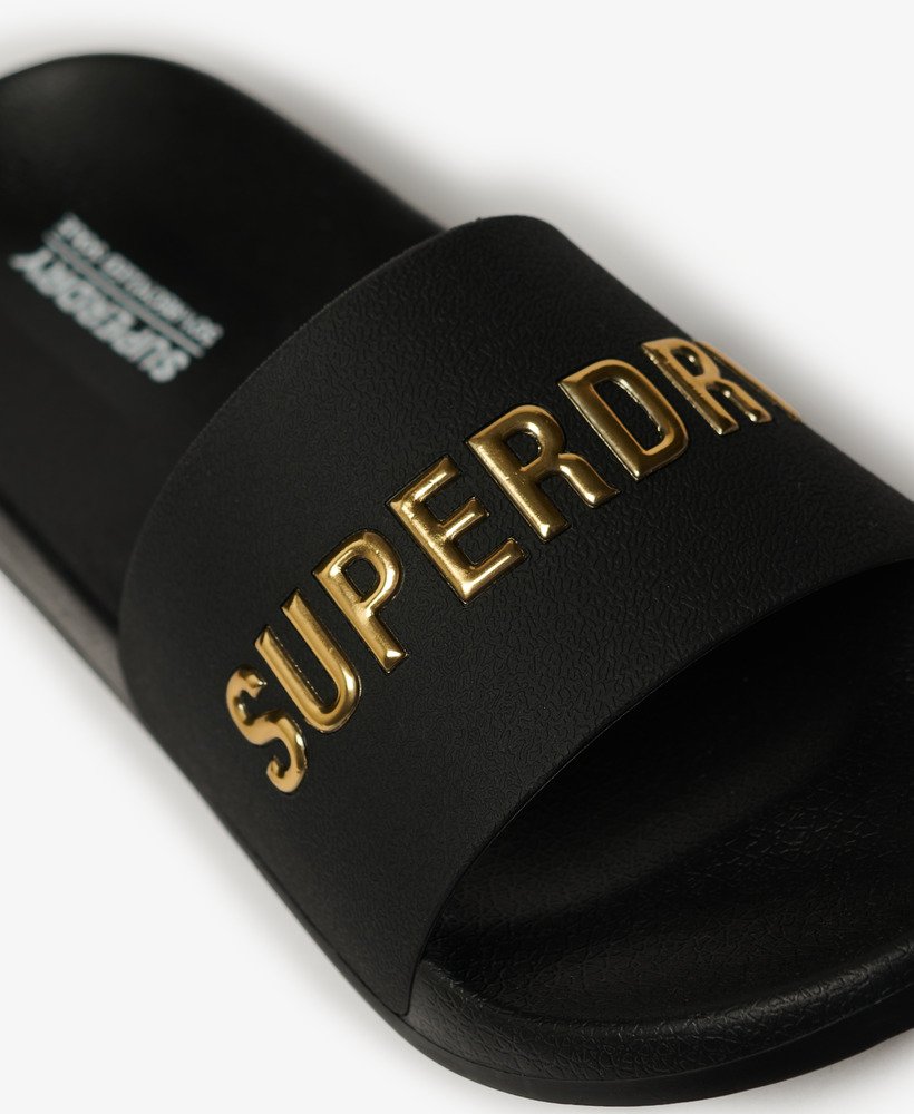 chinelo de piscina com logo vegano em pretodourado metálico