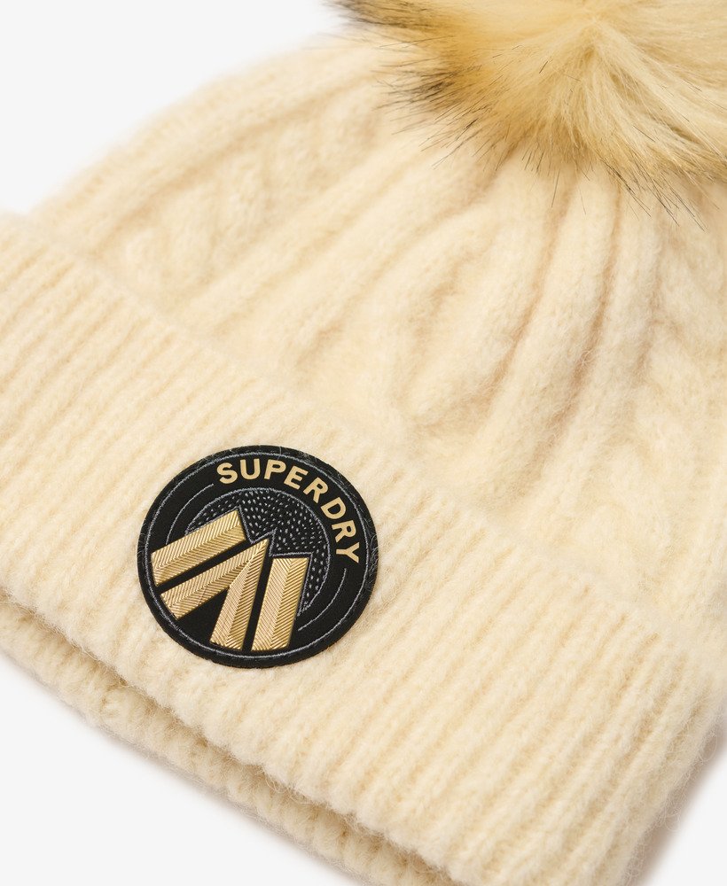 gorro de malha trançada na cor aveia e branco.
