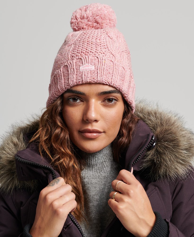 gorro de malha trançada com pompom em tweed rosa.