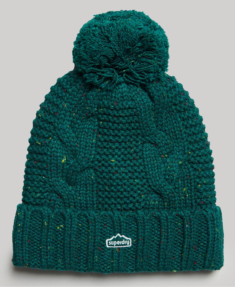 gorro de malha trançada com pompom em tweed verde-floresta.
