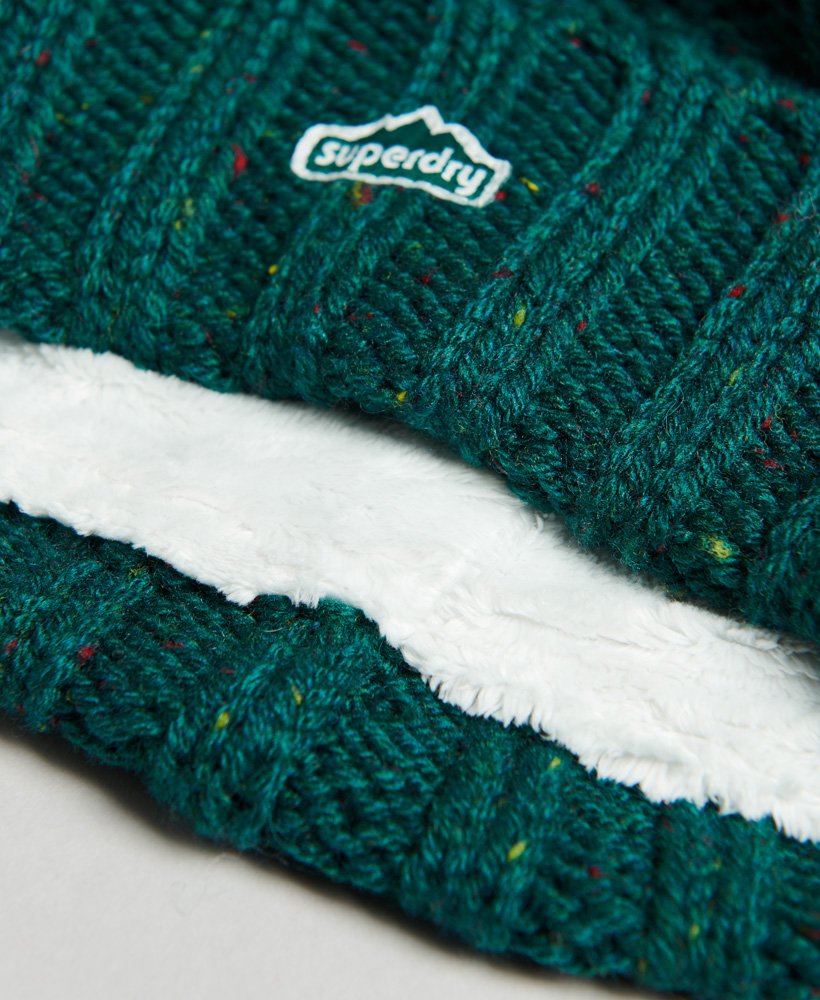 gorro de malha trançada com pompom em tweed verde-floresta.