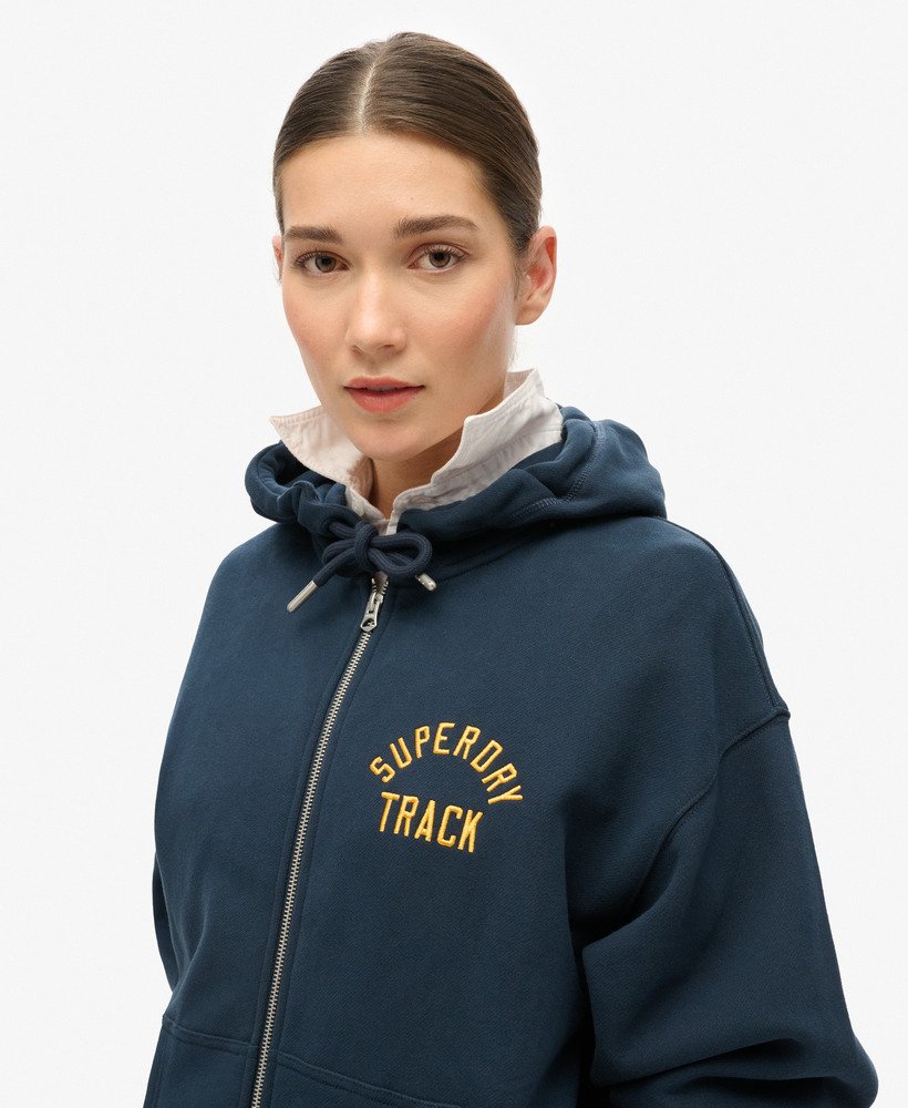 moletom com capuz e zíper estilo namorado com logo universitário em azul marinho.
