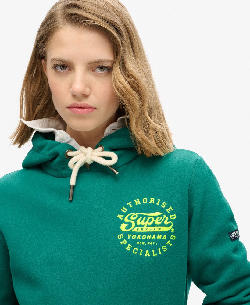 moletom com capuz e estampa bordada em neon na cor verde tempestade.