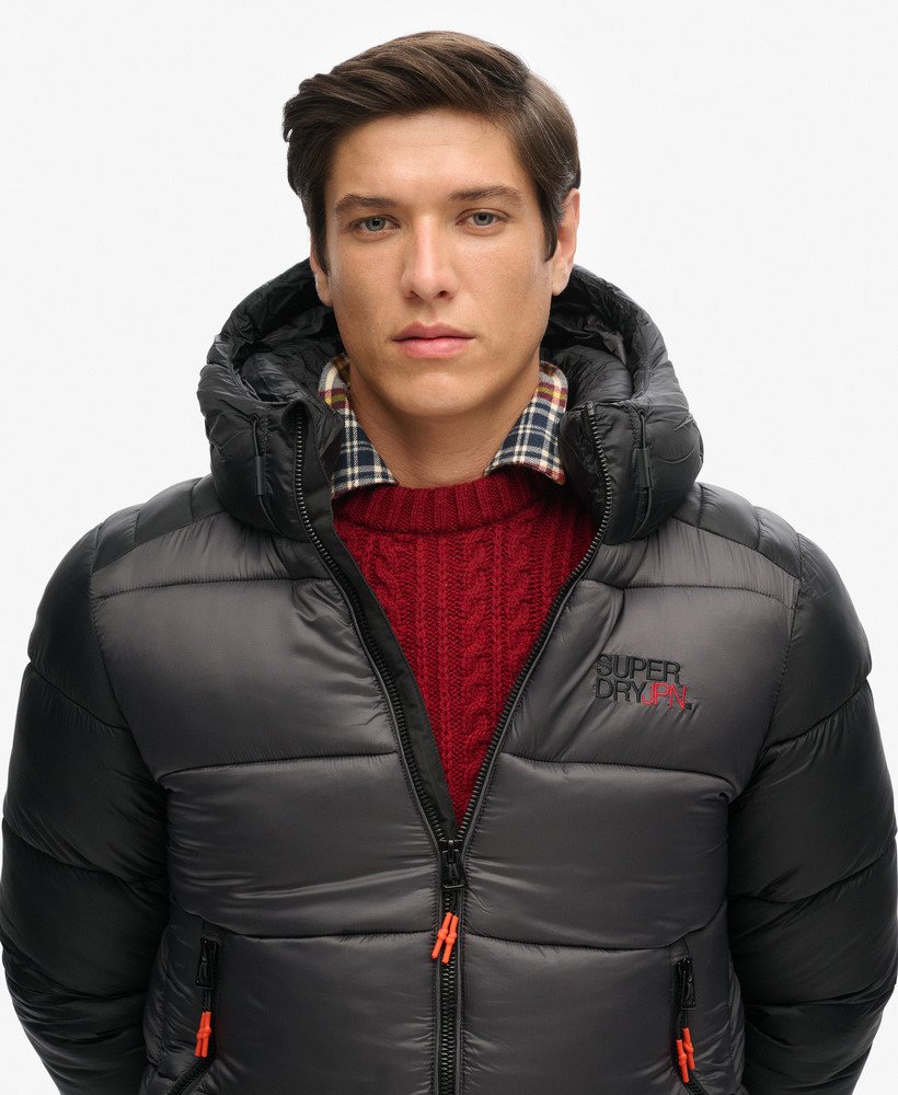 jaqueta esportiva puffer com capuz e blocos de cores na cor preta.