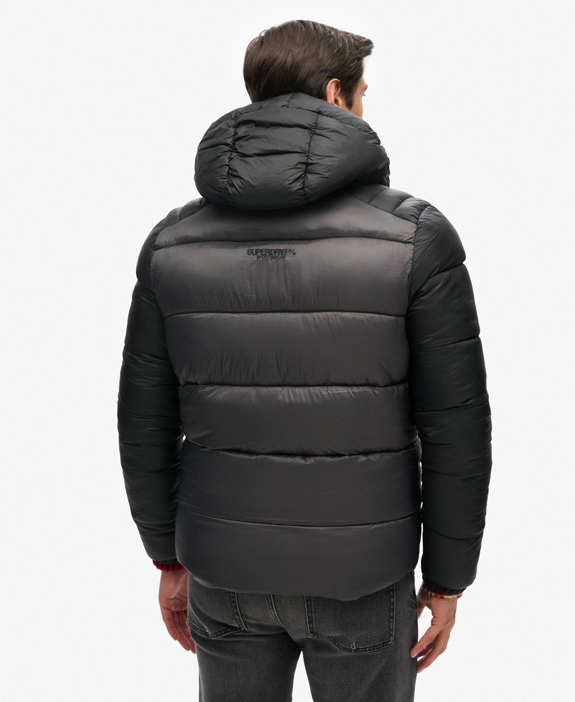 jaqueta esportiva puffer com capuz e blocos de cores na cor preta.