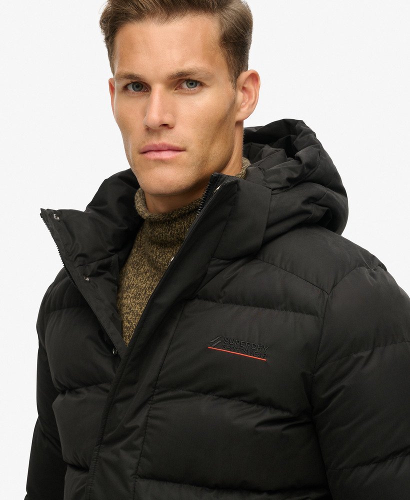jaqueta esportiva puffer com capuz em microfibra na cor preta.