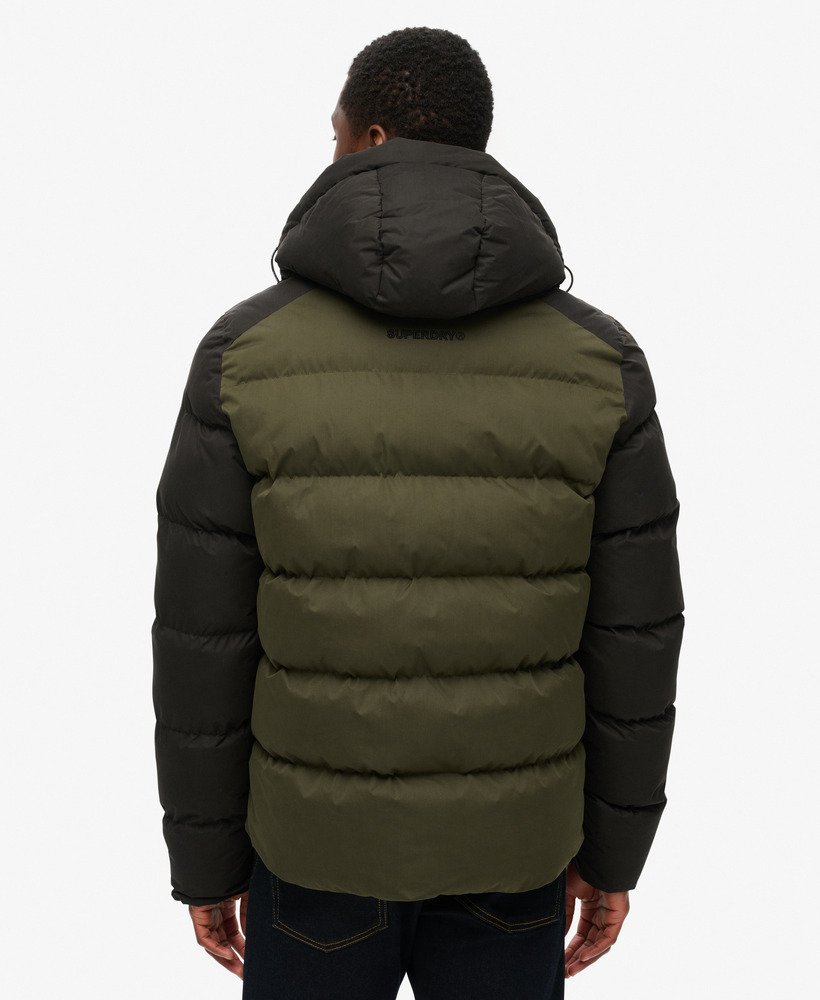 jaqueta puffer esportiva com capuz e blocos de cores na cor preta.