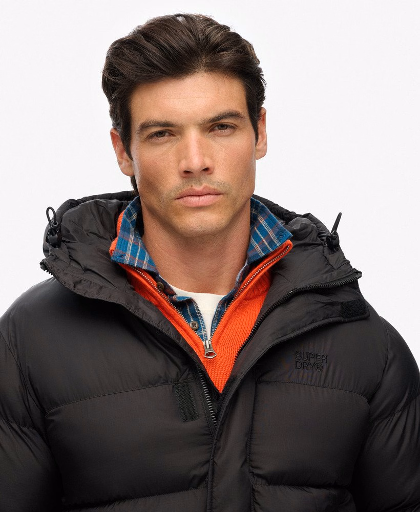 Jaqueta puffer preta com capuz.