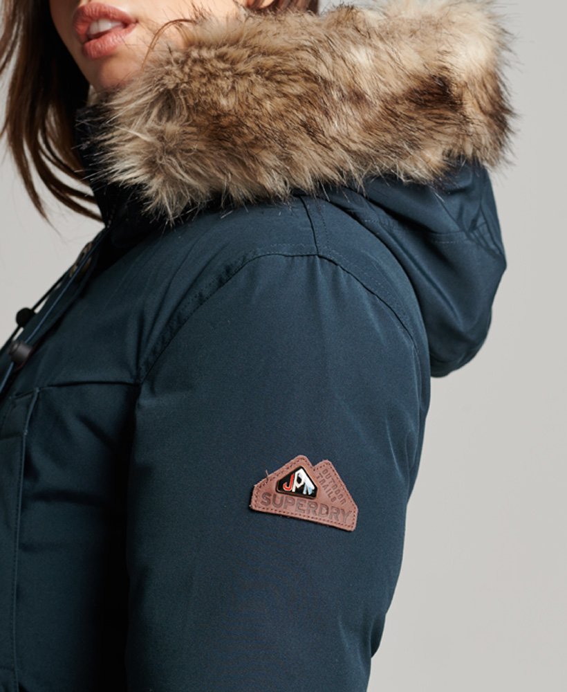 casaco parka com capuz e forro de plumas de pele sintética na cor azul marinho.