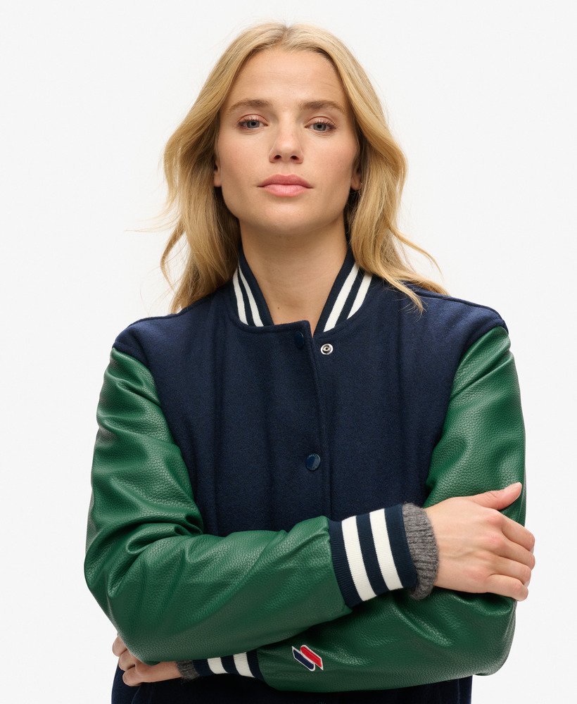 jaqueta estilo colegial de beisebol em lã nas cores verde-escuro e azul-marinho profundo.