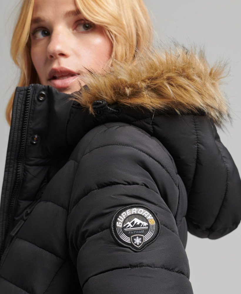 casaco puffer longo com capuz e leve acolchoado em pele sintética na cor preta.