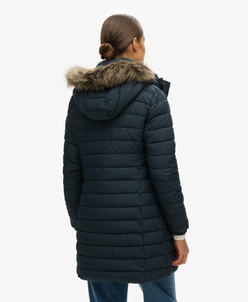 jaqueta puffer de comprimento médio com capuz e forro de pele sintética na cor azul marinho eclipse.