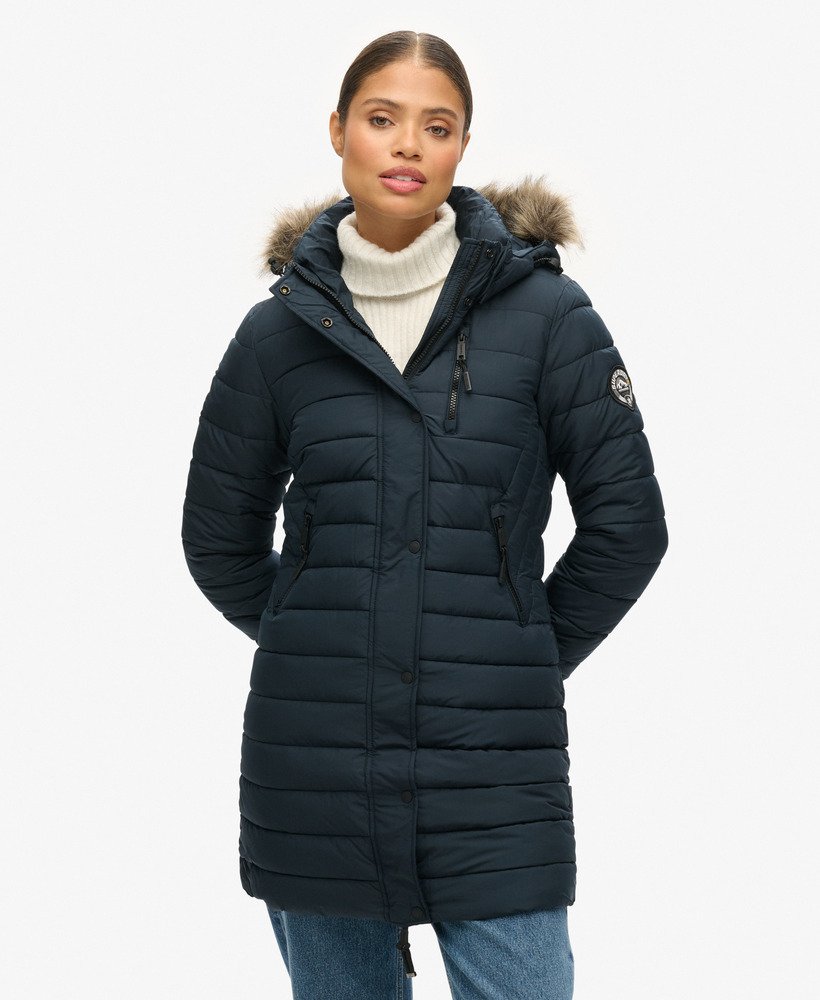 jaqueta puffer de comprimento médio com capuz e forro de pele sintética na cor azul marinho eclipse.