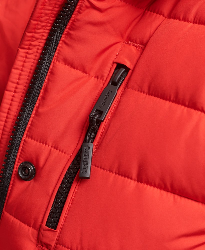 jaqueta puffer de comprimento médio com capuz e forro de pele sintética na cor vermelho high risk.