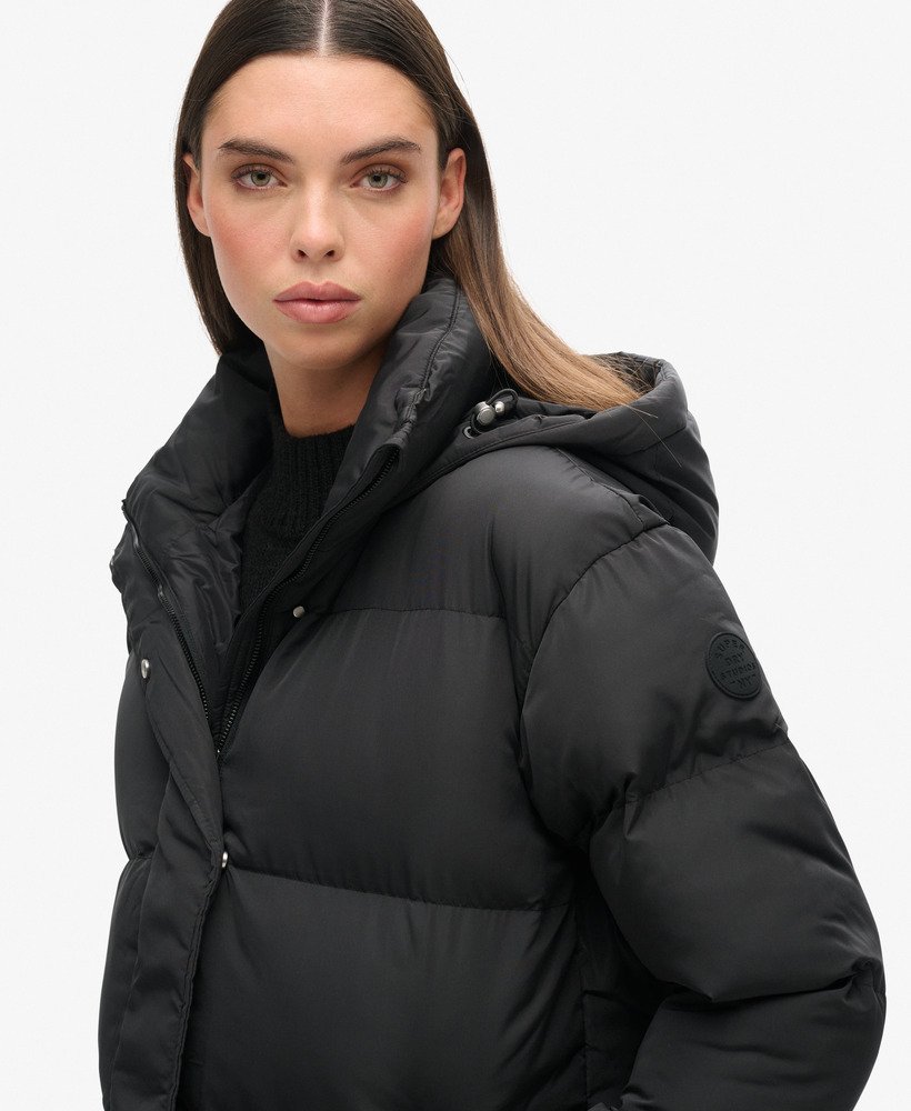 casaco puffer longo com capuz na cor preta.
