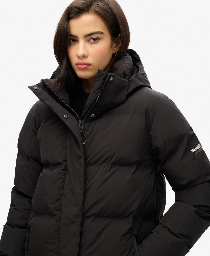 casaco puffer longo com capuz na cor preta.