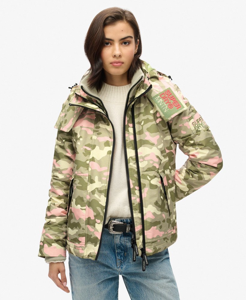 jaqueta corta-vento com capuz para montanha em camuflagem rosa e verde-marinho.