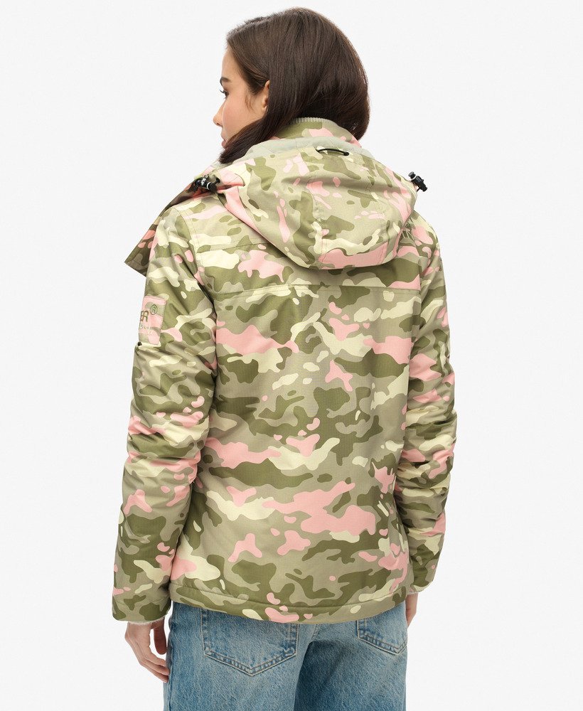 jaqueta corta-vento com capuz para montanha em camuflagem rosa e verde-marinho.