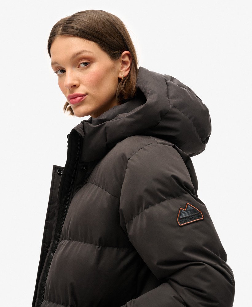 casaco puffer longo de microfibra na cor preta.