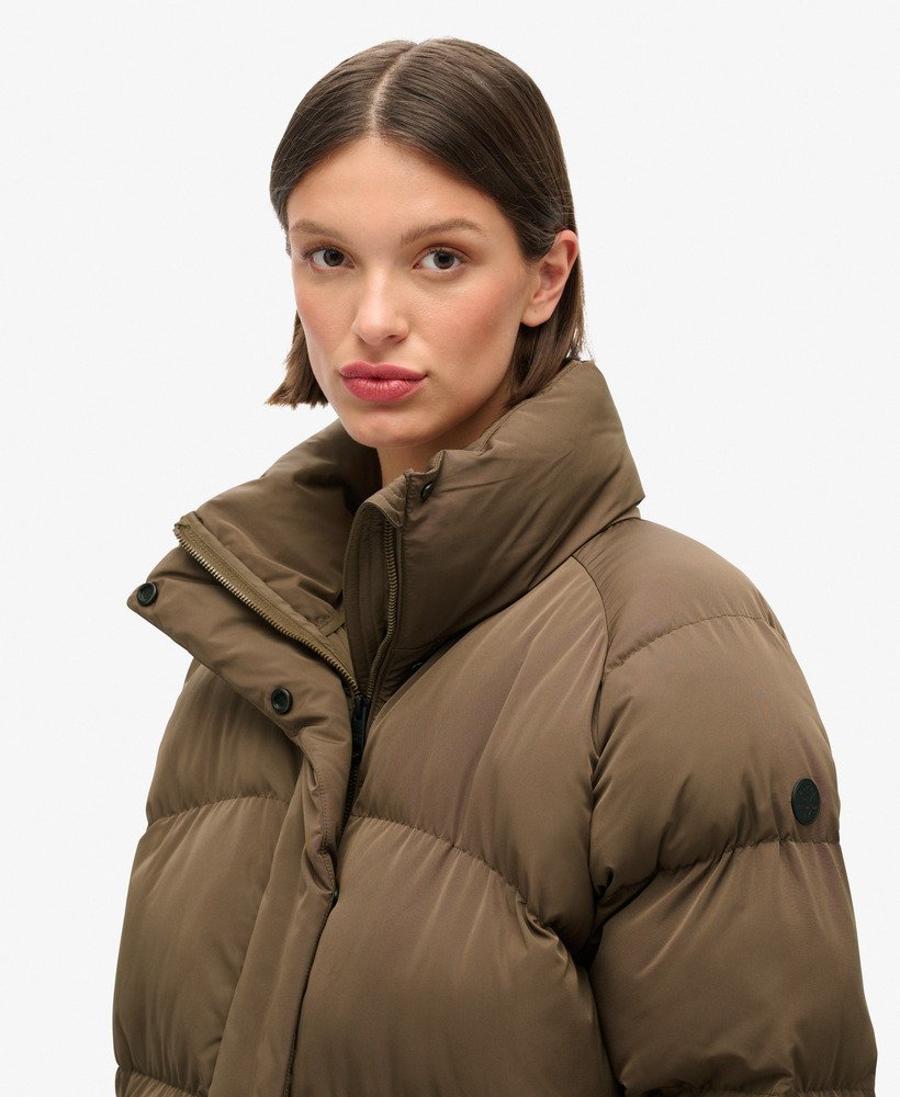 jaqueta puffer de comprimento médio em tom marrom quente.
