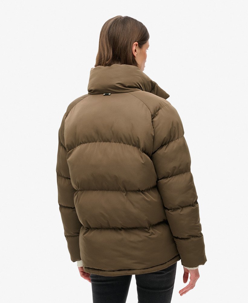 jaqueta puffer de comprimento médio em tom marrom quente.