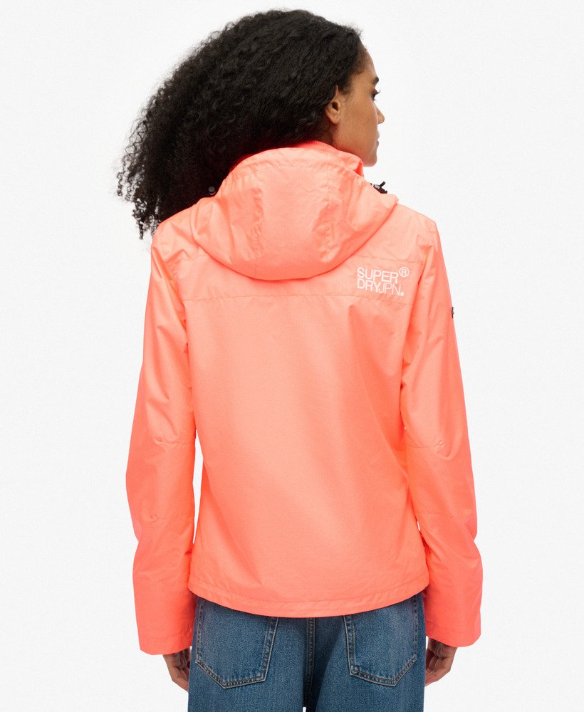jaqueta corta-vento com capuz para montanha na cor coral pastel.
