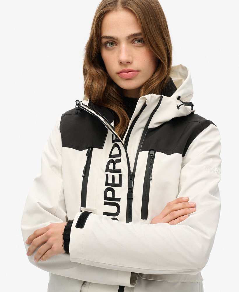 jaqueta corta-vento ultimate com blocos de cores em branco e preto.