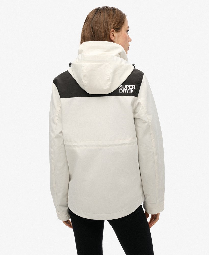jaqueta corta-vento ultimate com blocos de cores em branco e preto.