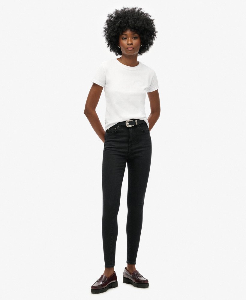 calça jeans skinny de cintura alta em algodão orgânico com lavagem preta.