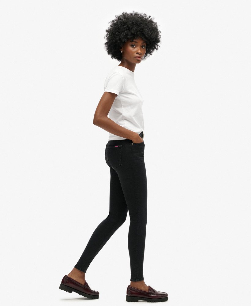 calça jeans skinny de cintura alta em algodão orgânico com lavagem preta.