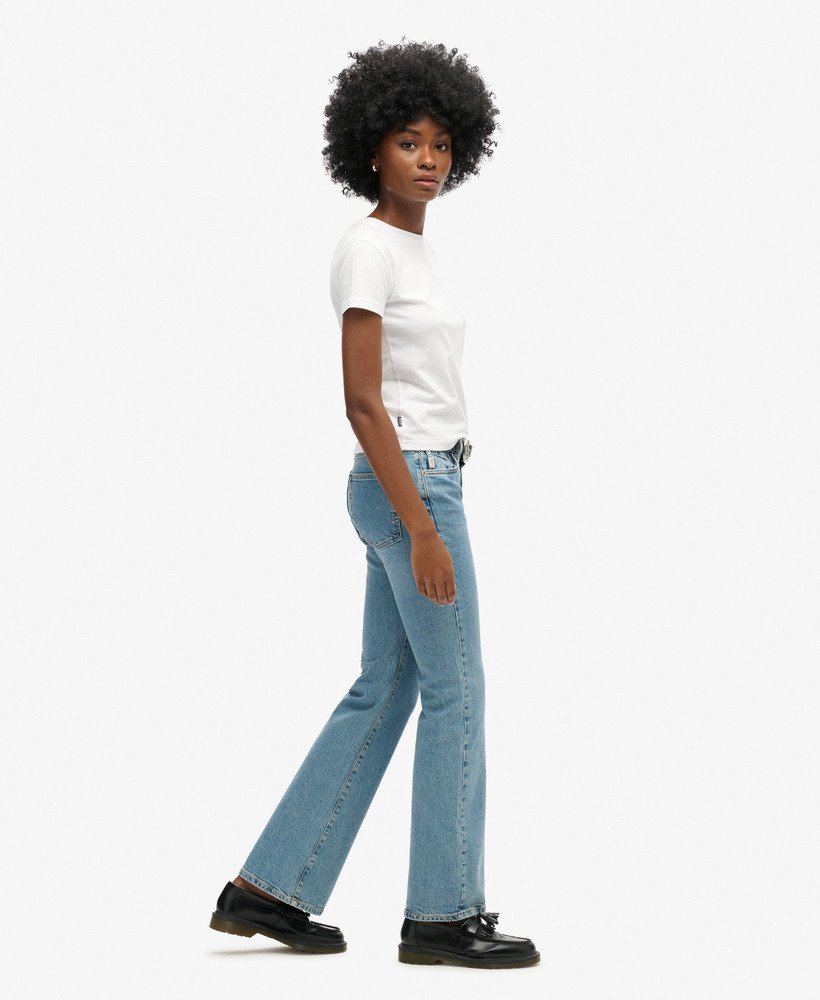 calça jeans vintage de cintura média corte flare slim em índigo escuro envelhecido.