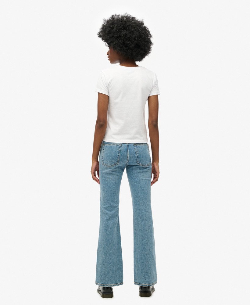 calça jeans vintage de cintura média corte flare slim em índigo escuro envelhecido.
