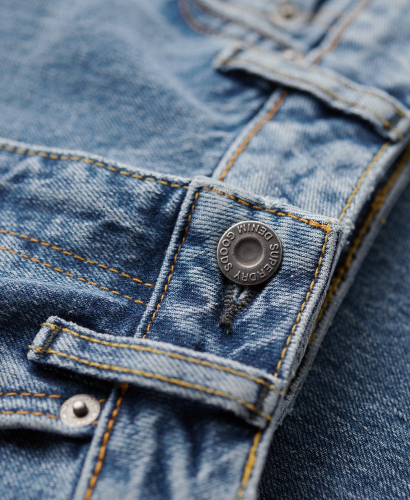 calça jeans vintage de cintura média corte flare slim em índigo escuro envelhecido.