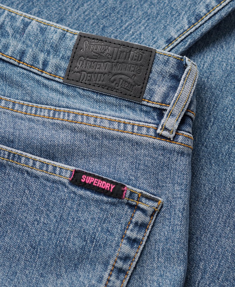 calça jeans vintage de cintura média corte flare slim em índigo escuro envelhecido.