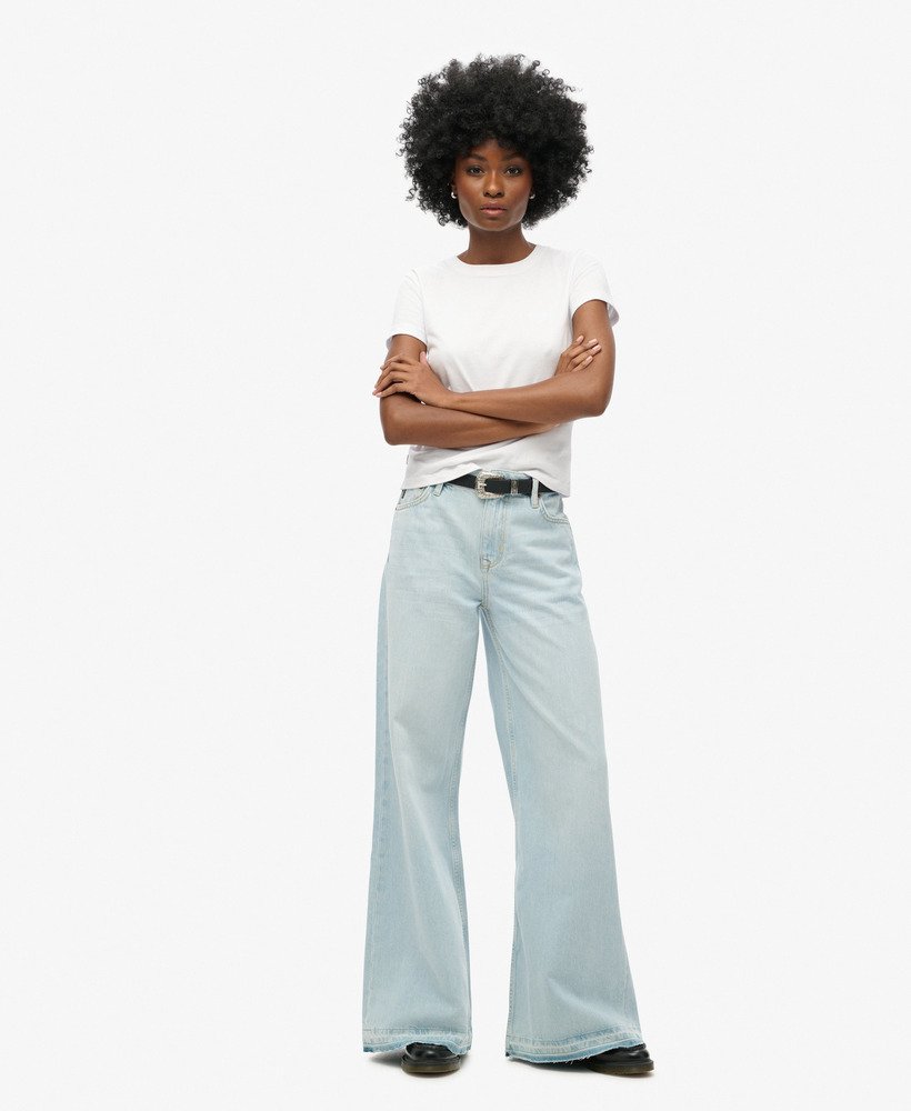 calça jeans flare de perna larga com barra desfiada na cor azul claro phoenix.