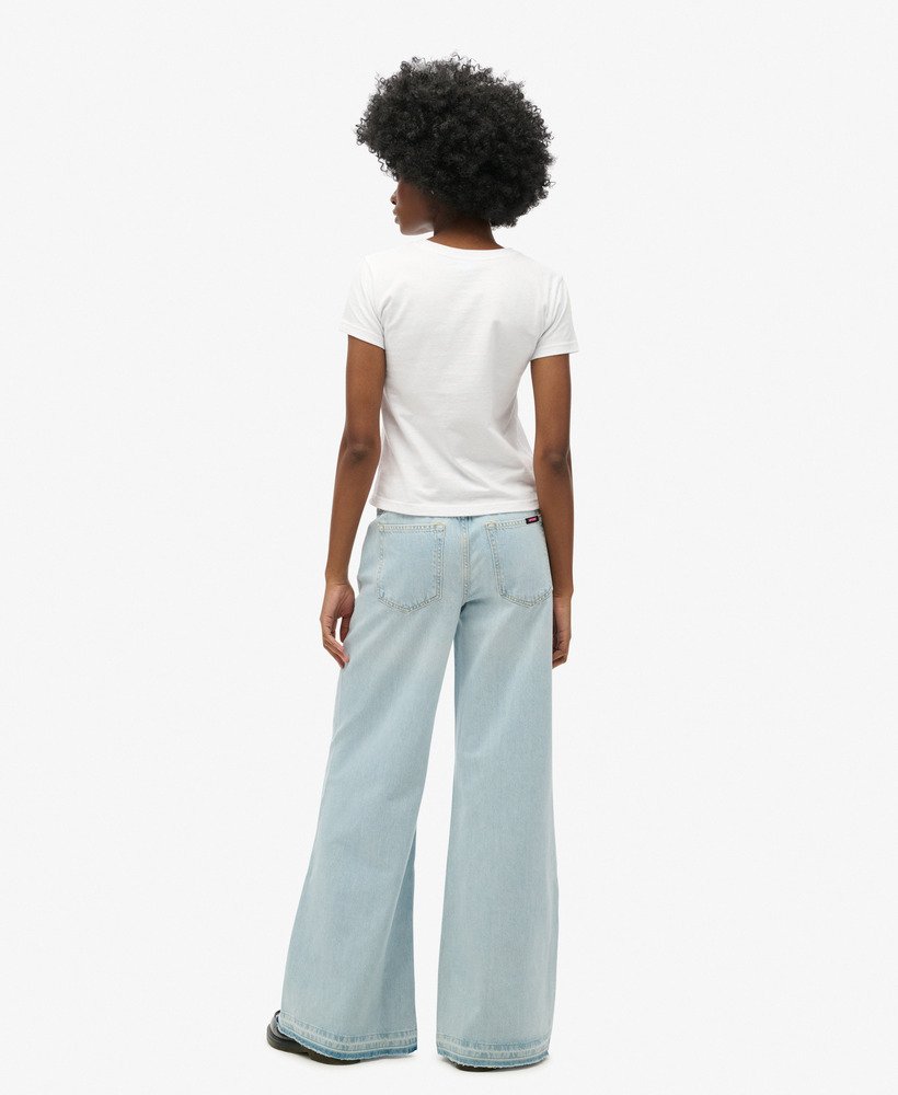 calça jeans flare de perna larga com barra desfiada na cor azul claro phoenix.