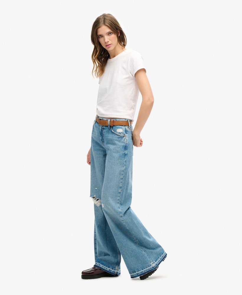 calça jeans flare de perna larga com barra desfiada na cor azul sun beach.